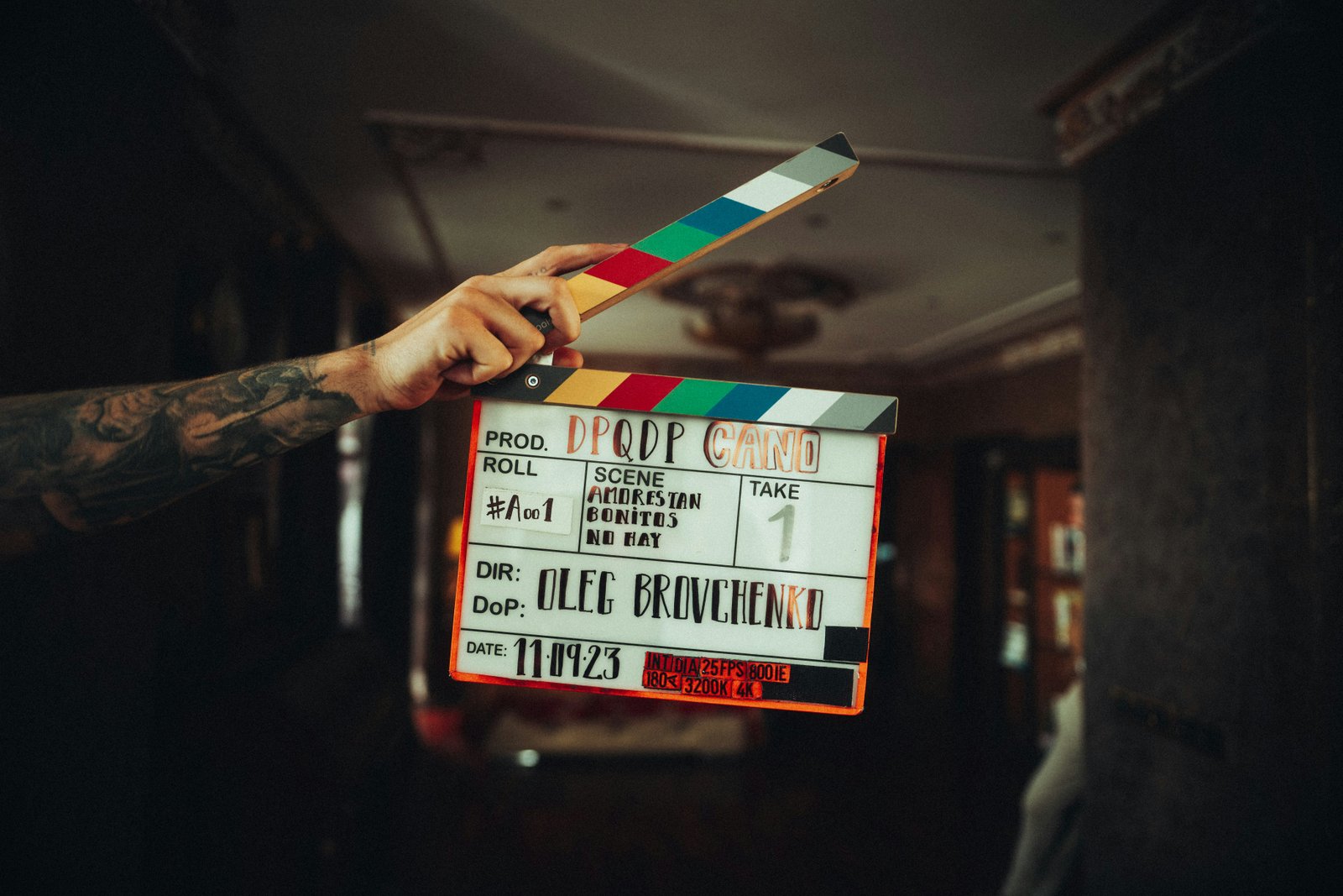 A hand holding up a film clapperboard, ready to film a scene.