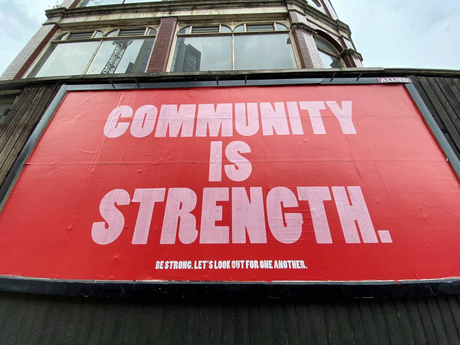 A red billboard reading 'Community is Strength.'