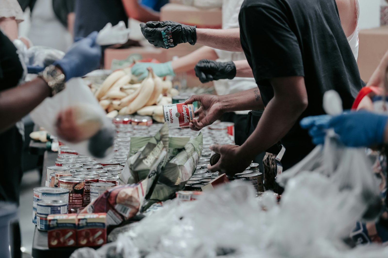 Volunteers sorting canned goods and produce at a food bank.