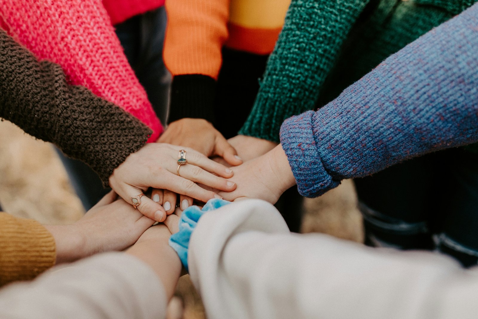 A group of hands stacked together in a show of unity and teamwork.