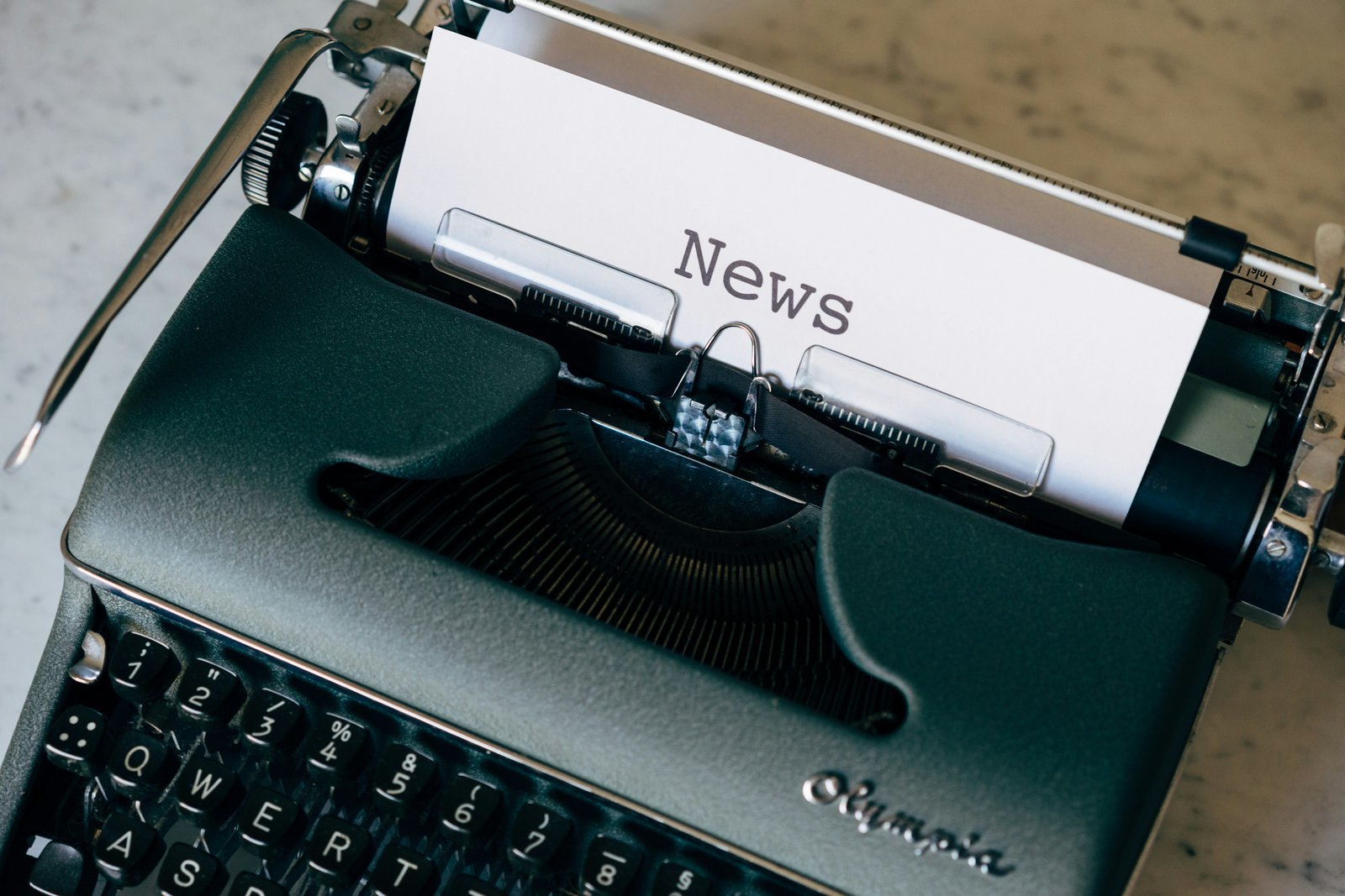 A vintage typewriter with a sheet of paper reading 'News.'