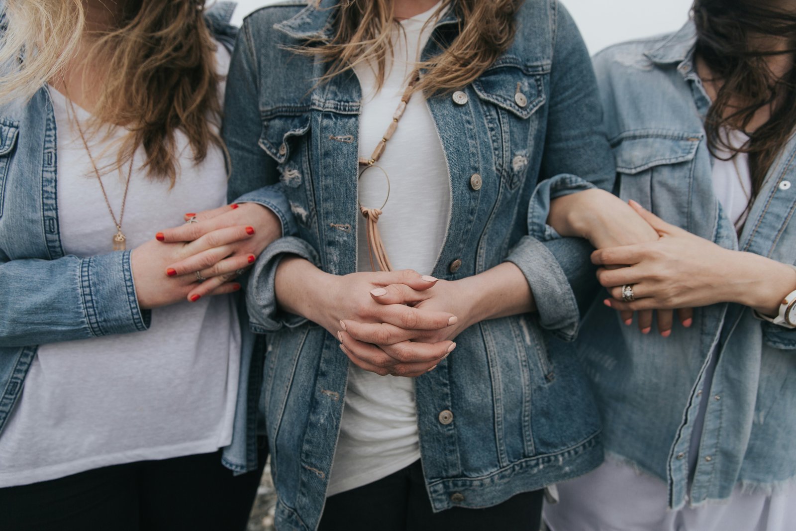 Close-up of women linking arms together in support of one another.